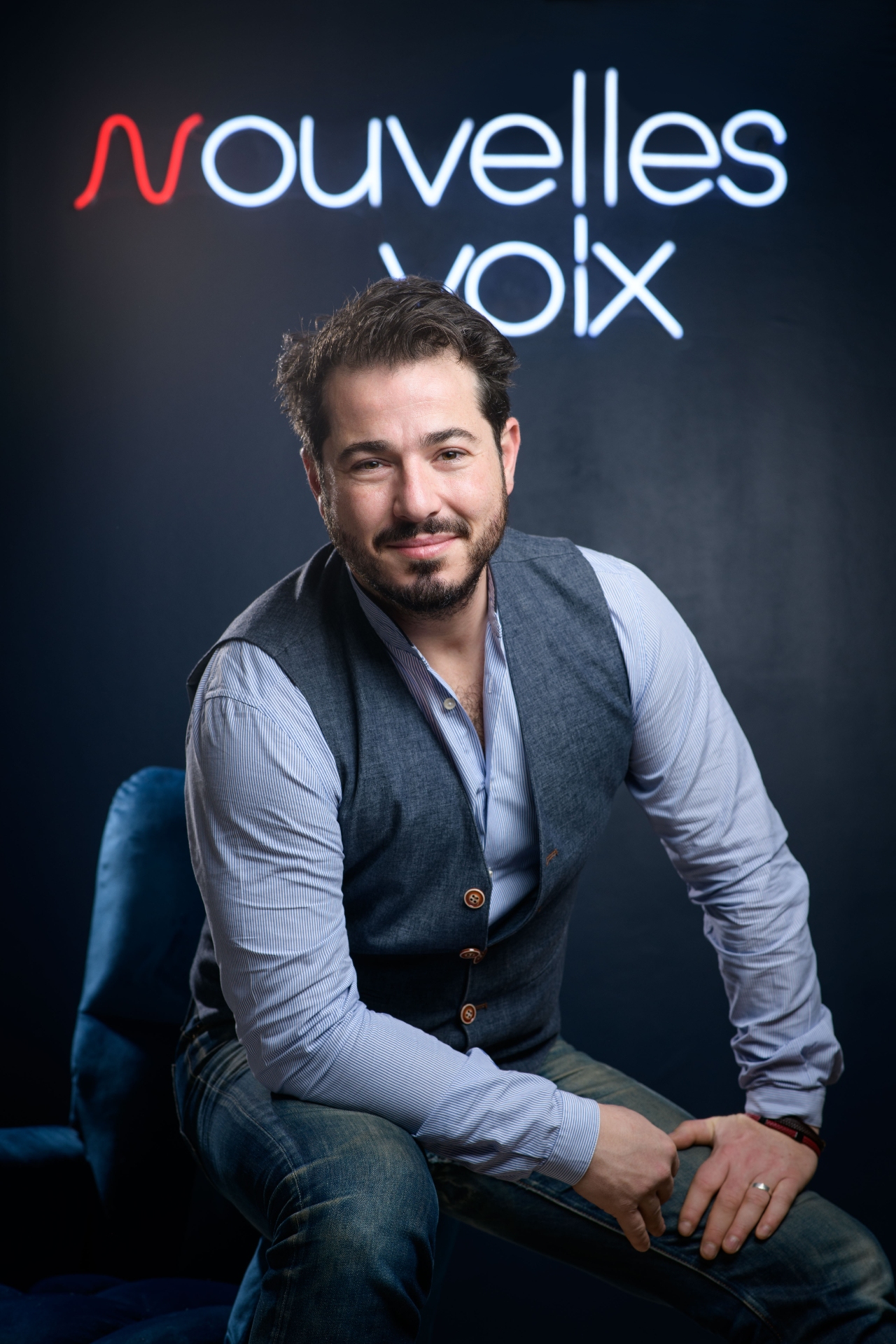 David Gordon devant le néon Nouvelles Voix